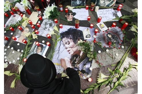 Ein Michael Jackson-Fan zündet Kerzen an einer Gedenkstätte in Berlin an.