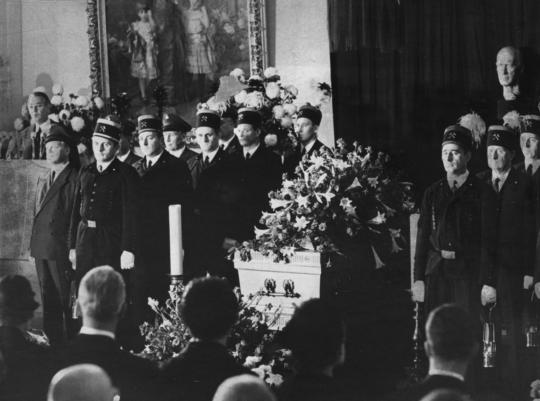 3. August 1967: Der Generalbevollmächtigte von Krupp, Berthold Beitz (links am Rednerpult), nimmt auf der Trauerfeier in der großen Halle der Villa Hügel Abschied von Alfried Krupp von Bohlen und Halbach, der am 30.07.1967 verstorben ist.
Knappen in Bergmannsuniformen umstehen den Sarg.