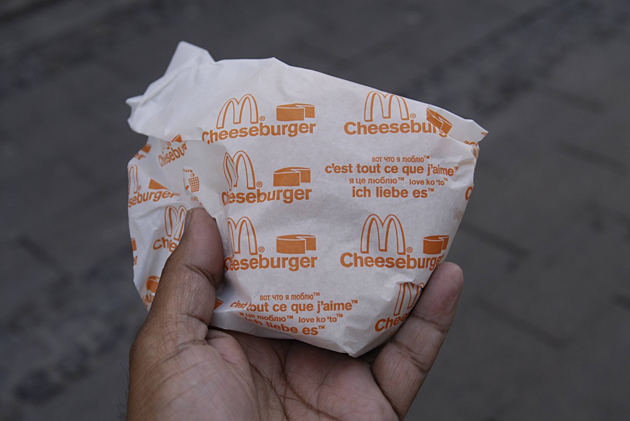 Eine Kundin von McDonalds will die Verpackung von ihrem Cheeseburger entfernen und muss feststellen, dass der Patty fehlt. (Symbolbild)