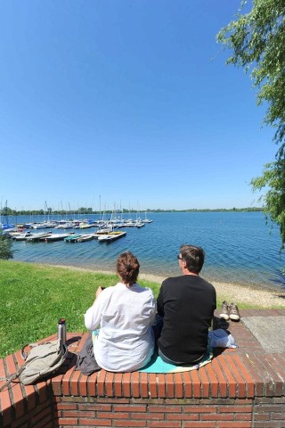 Am Freitag, 25.05.2012, blickt ein Paar auf die Xantener Nordsee. Bei schönem Wetter hat sich das Paar auf einer Mauer in Xanten zu einem Picknick niedergelassen.  Foto : Markus Weißenfels / WAZ FotoPool