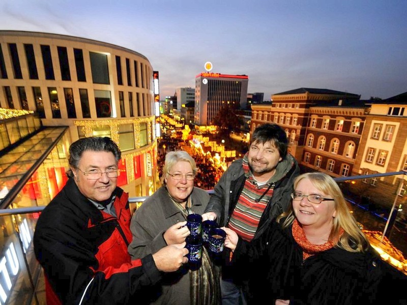 Am Samstag, den 19.11.2011 strömen tausende Besucher am ersten Wochenende auf den Weihnachtsmarkt in Duisburg - Mitte. Bei trockenem kühlen Wetter geniessen die Leute Glühwein , Leckereien oder kaufen schon mal das ein oder andere Geschenk für Weihnachten. Hoch über dem Weihnachtsmarkt auf der Terrasse von Karstadt im Forum geniessen v.l. Ulrich und Heinke Wierusz mit Friedrich Berthold und Manuela Gottschlich einen GlühweinFoto: Stephan Eickershoff / WAZ FotoPool