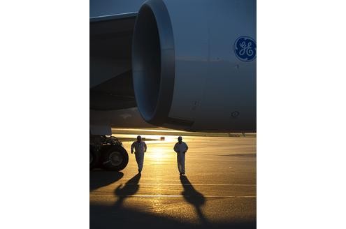 Jet und Techniker auf dem Rollfeld im Sonnenuntergang.