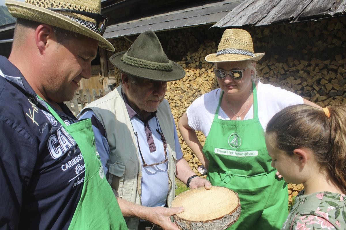 Beim Holzschneiden eines Baumstammes gibt Hans Zach (2.v.l.) die nötige Hilfestellung. 