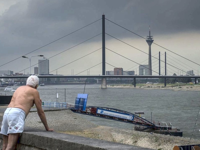 Ein Mann beobachtet das Gewitter am Rheinufer in Düsseldorf.Foto: Bernd Lauter / WAZ FotoPool