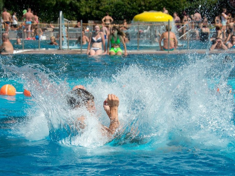 Ein Mann taucht im Schwimmbad Einsiedel in Zella-Mehlis nach einem Sprung vom Brett ins Wasser ein.