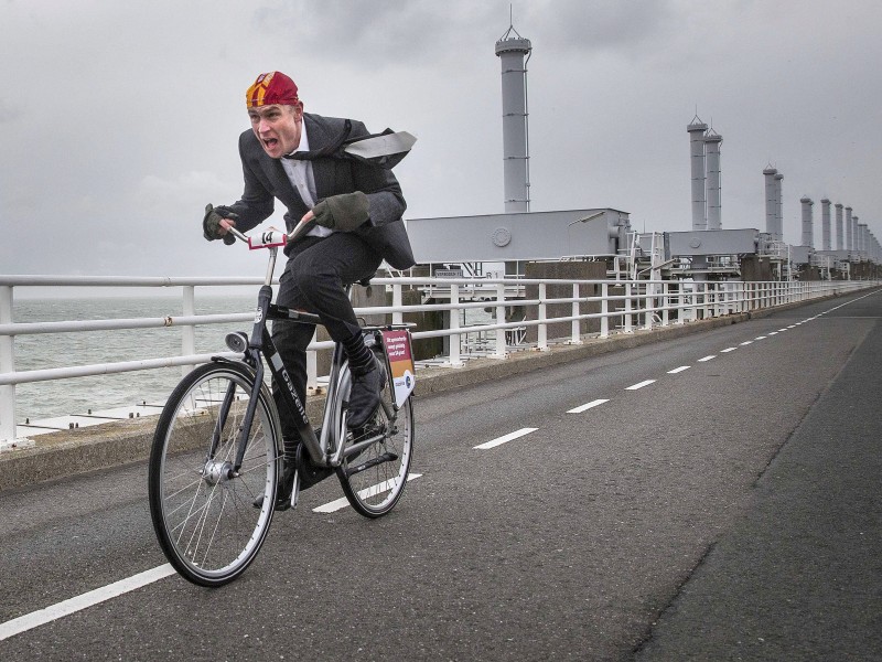 ...einen kuriosen Fahrrad-Wettbewerb. Das Foto zeigt einen Teilnehmer beim Dutch National Championship 'Cycling against the wind' am  Deltawerk der Osterschelde in Zeeland. Man beachte die windschlüpfrige Haube des Herrn auf dem Hollandrad - die Niederländer wissen eben, wie man gegen Wind radfährt.