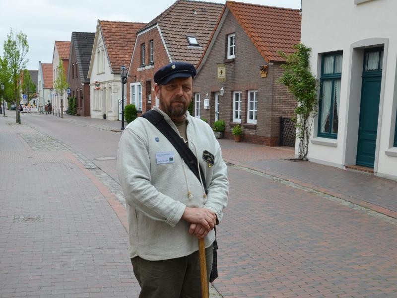 Dirk Arnskötter hält einen Spaten zwischen den Händen - er macht in Neustadgödens Stadtführungen als Koyer, wie die Deichbauarbeiter an der Küste hießen.