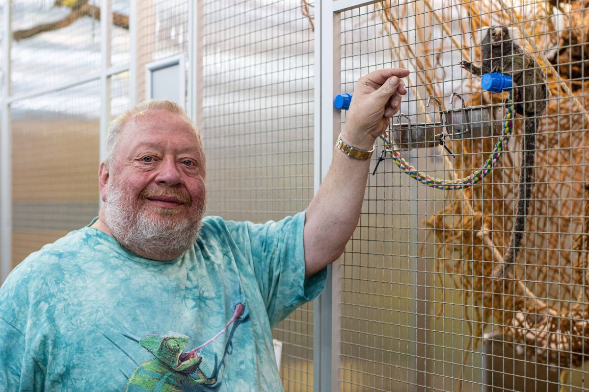 Norbert Zajac vom Zoo Zajac in Duisburg vor einem Vogelkäfig