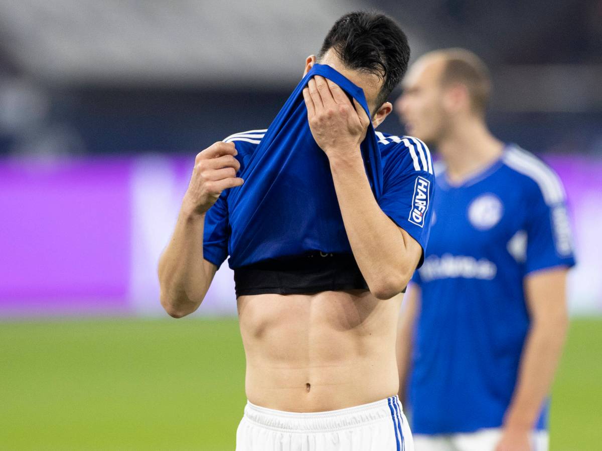 Maya Yoshida zieht sich vor Frust das Trikot des FC Schalke 04 vors Gesicht.