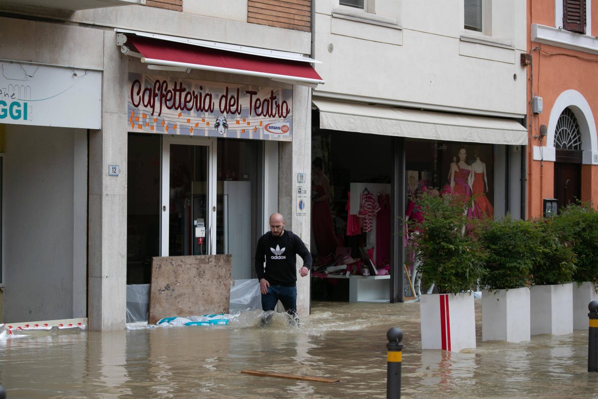 Mann steht in Italien in EinkaufsstraÃŸe knietief im Wasser