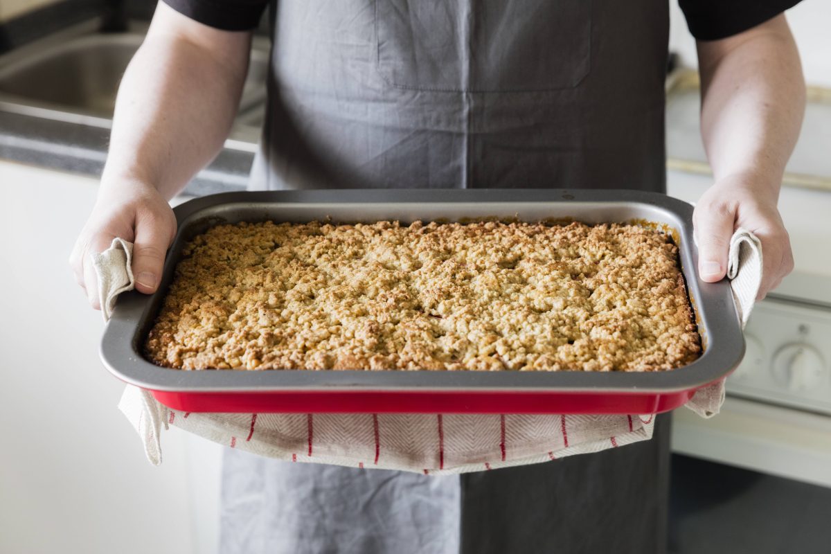 BÃ¤cker hÃ¤lt ein Backblech Streuselkuchen