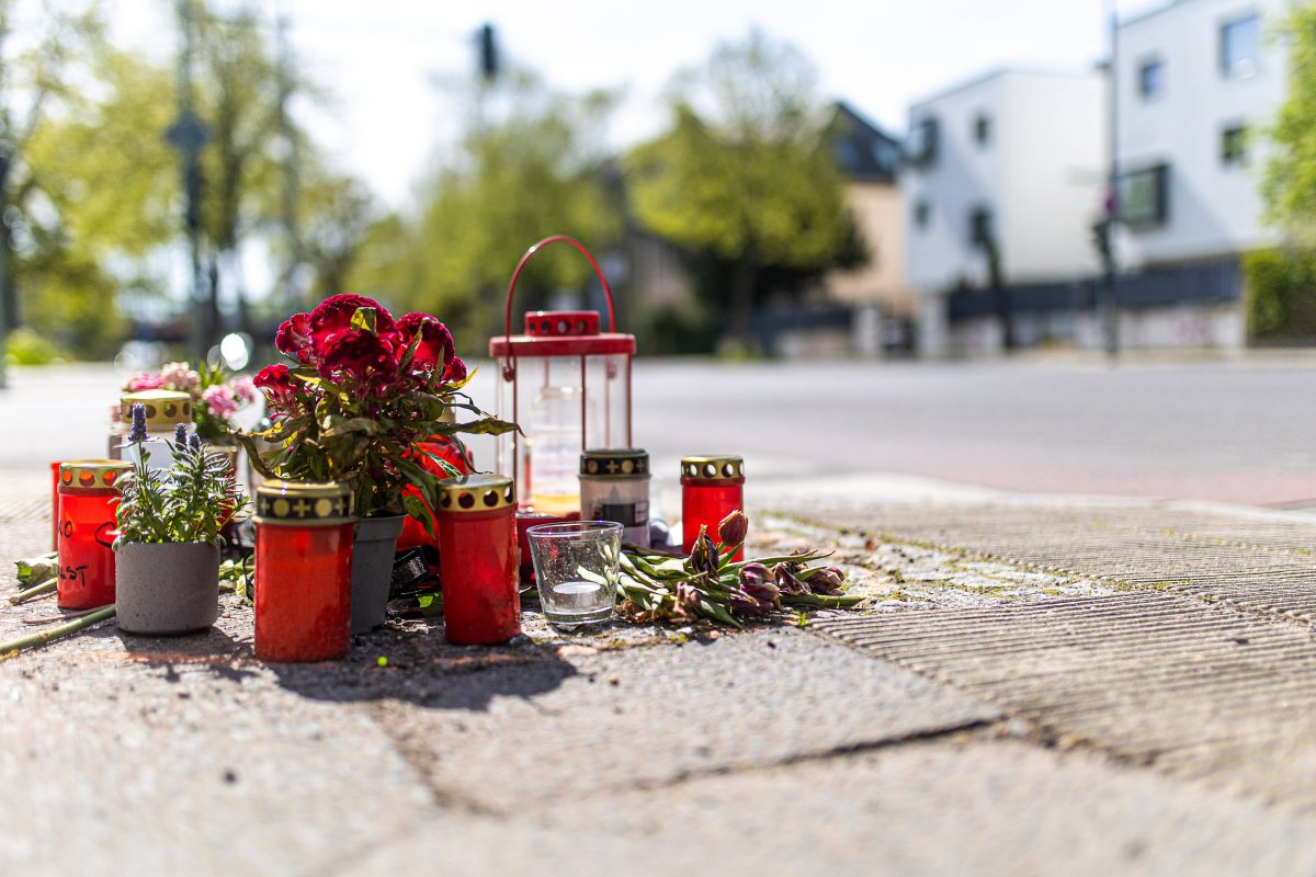 Trauerstelle an einer StraÃŸe mit Blumen und Kerzen