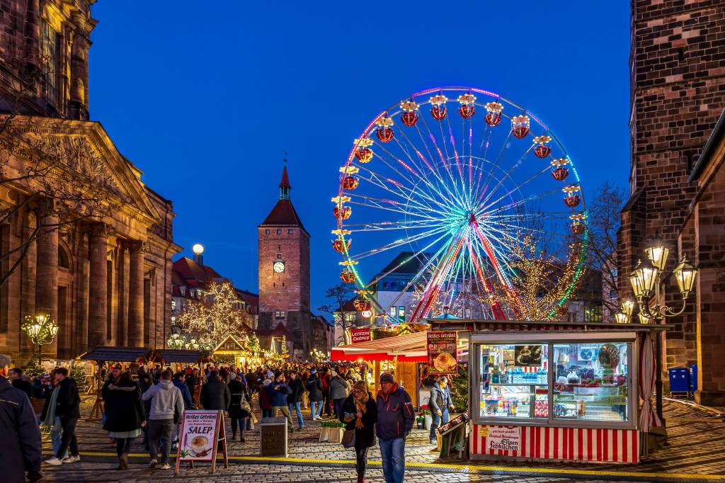 Riesenrad neben Kirchturm bei Nacht mit Weihnachtsbude