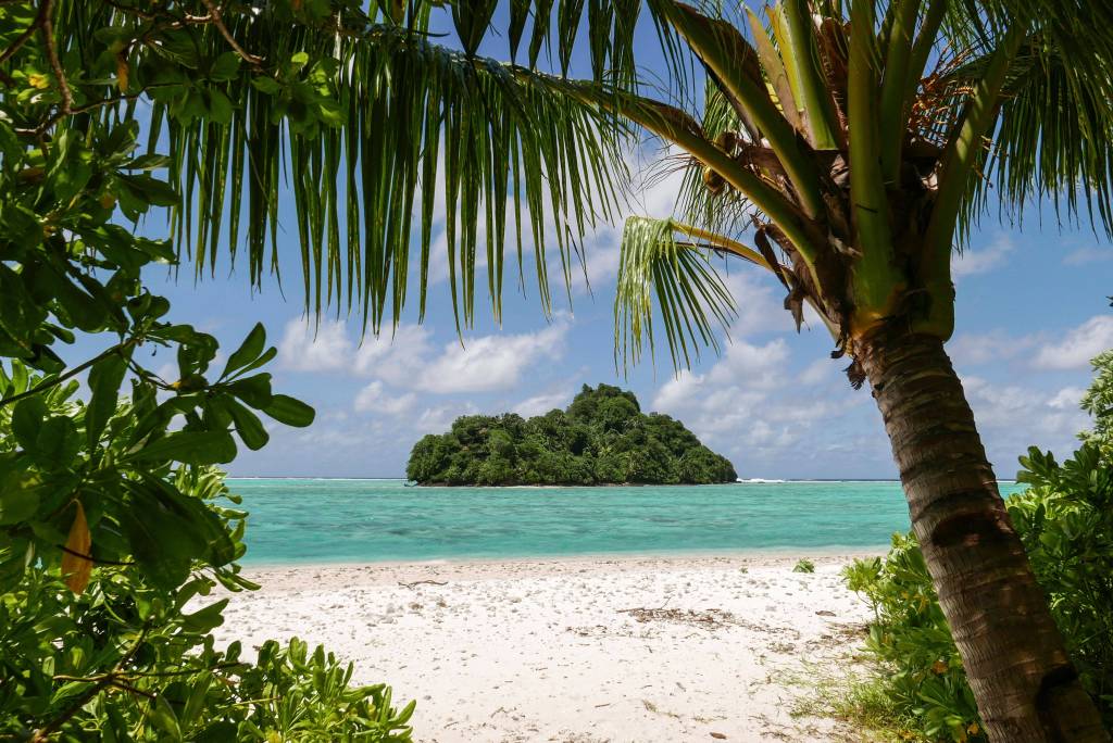 Ein Blick zwischen Palmen zu einer kleinen Insel von Wallis und Futuna, Platz 10 der Länder mit den wenigsten Einwohnern der Welt.