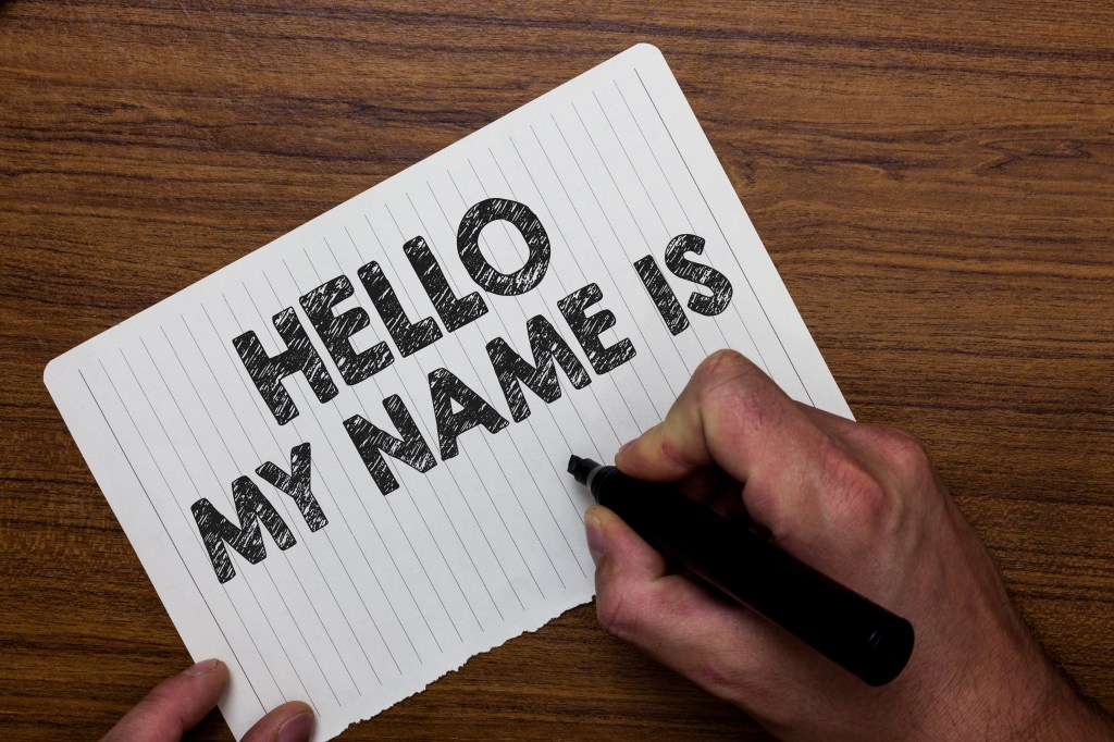 Auf einem Tisch liegt ein Zettel mit der Aufschrift "Hello m name is".