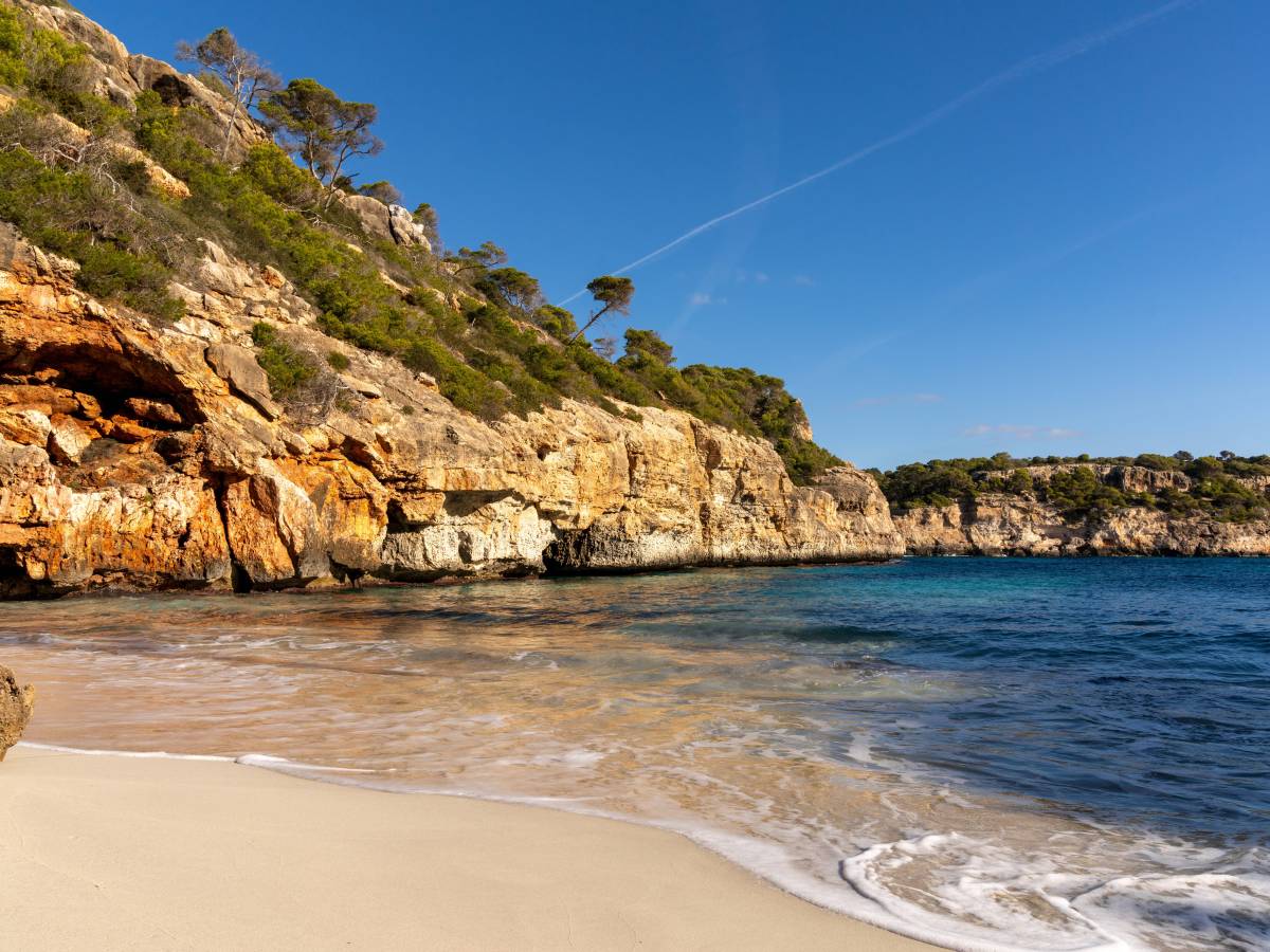 Sandstrand mit Felsen und Meer.