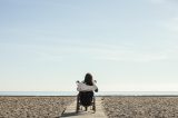 Frau im Rollstuhl am Strand