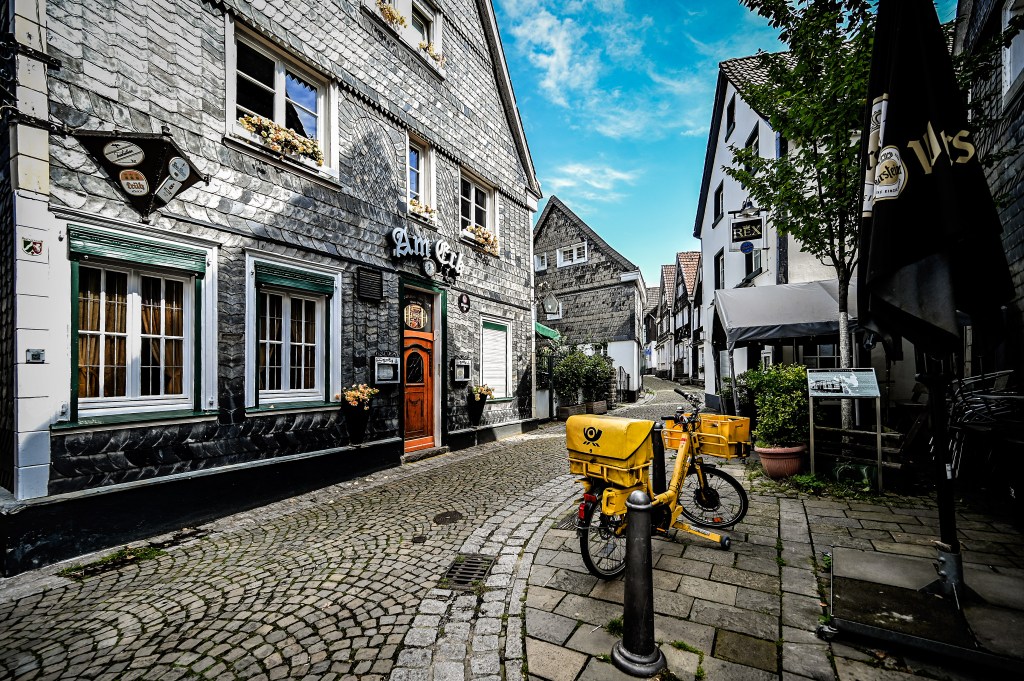 Ein Blick in eine Gasse des historischen Stadtviertel Kettwig in Essen mit Fachwerkhäusern und Kopfsteinpflaster.