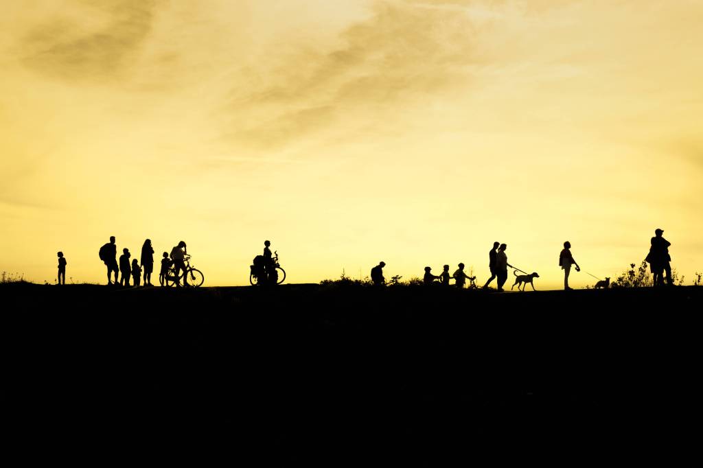 Schattige Silhouetten von Herrchen, Frauchen und Hunden bei Sonnenuntergang am Kaiserwerth, Düsseldorf