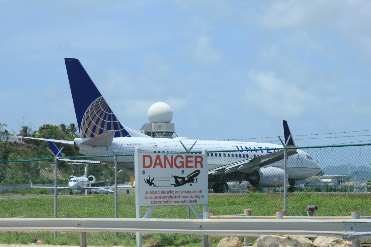 Flugzeug hinter Zaun mit Danger-Zeichen