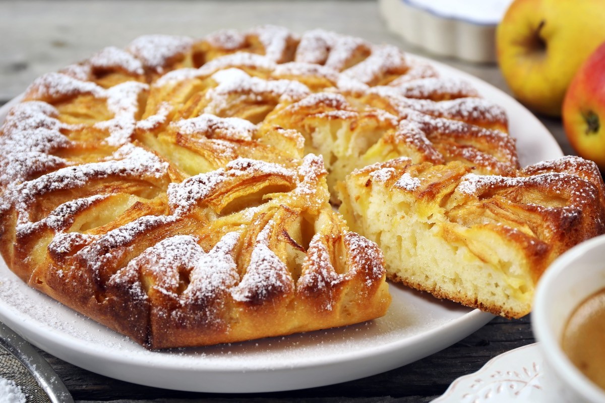 Ein ElsÃ¤sser Apfelkuchen mit Puderzucker auf einem Teller.